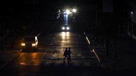 Personas cruzan la calle durante un apagón. (Foto de EFE)