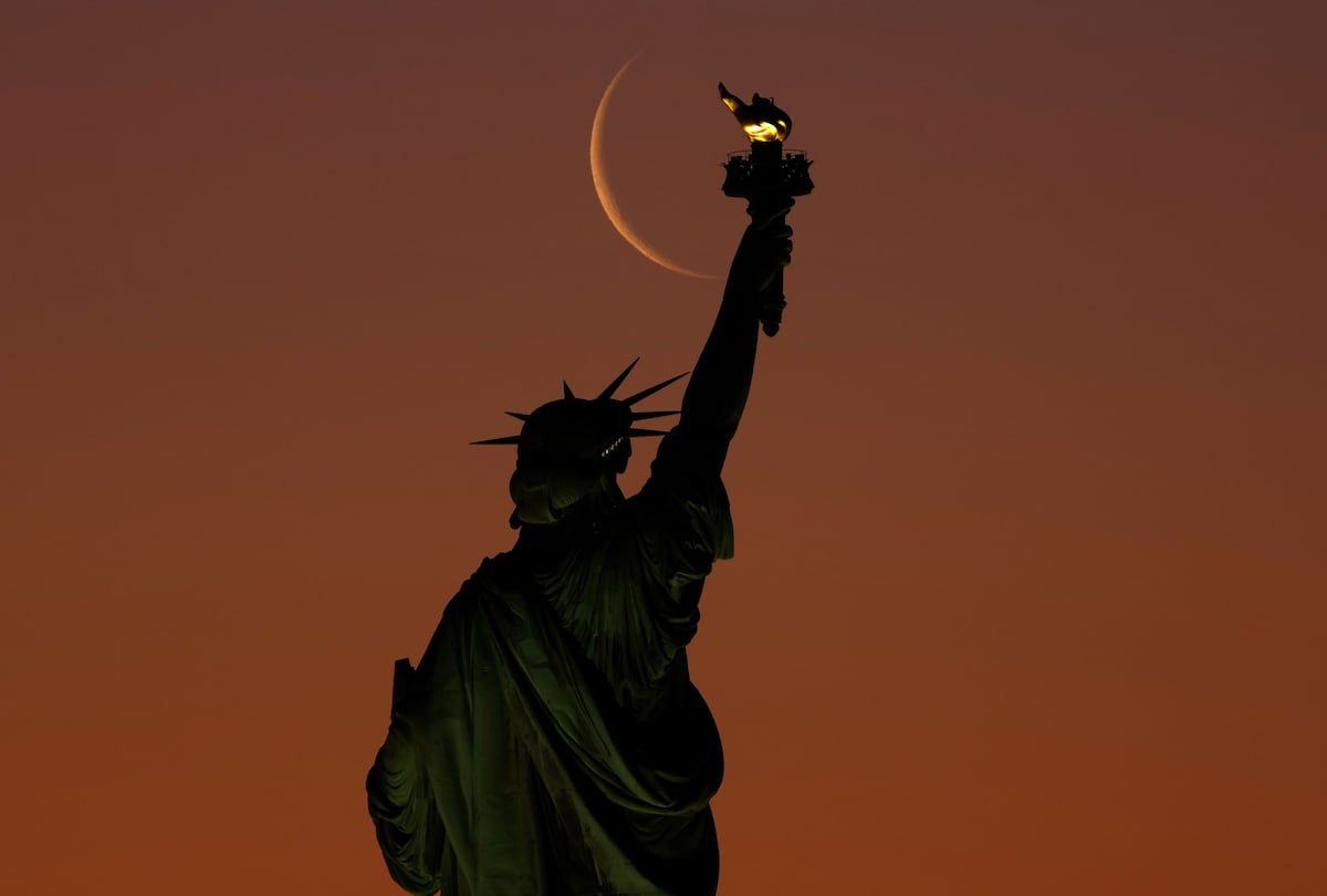Una luna menguante se alza tras la estatua de la Libertad al amanecer en la ciudad de Nueva York. (Foto: Gary Hershorn/Corbis News via Getty Images)