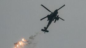 Un helicóptero de ataque de la fuerza aérea israelí lanza bengalas mientras vuela en un área a lo largo de la frontera con la Franja de Gaza, el 12 de diciembre de 2023. (Foto de JACK GUEZ / AFP)